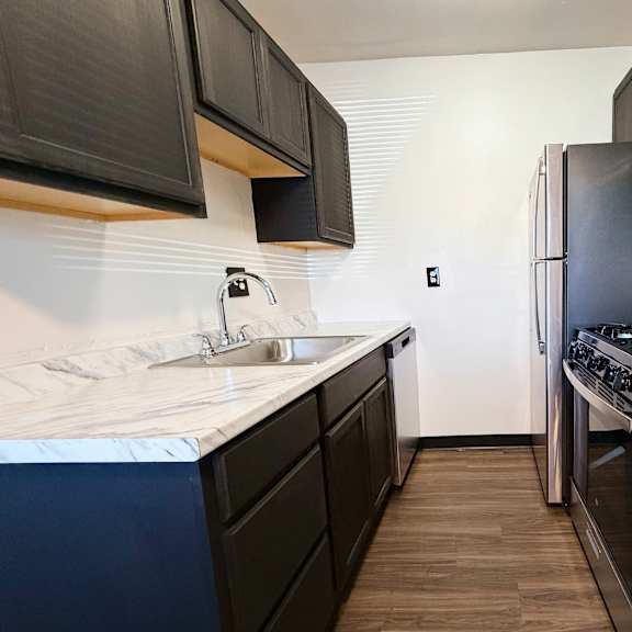 a kitchen with black cabinets and a white countertop.