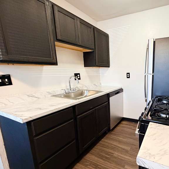 a kitchen with black cabinets and a white countertop.