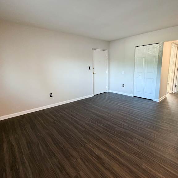 a room with wooden flooring and white walls.