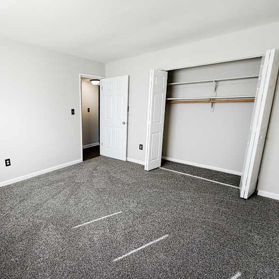a room with a grey carpet and a white door.