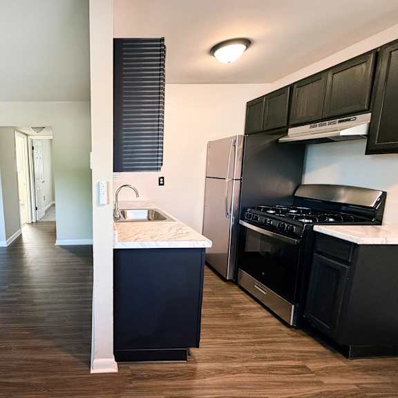 a kitchen with black cabinets and a white countertop.