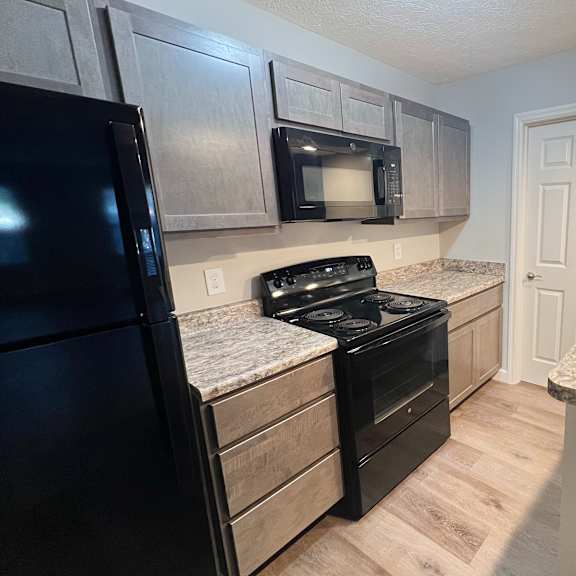 a kitchen with black appliances and granite counter tops at woodhills apartments, ohio, 45449