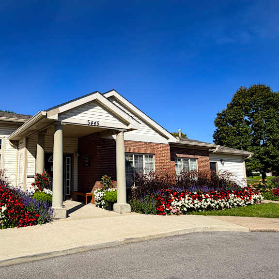 a house with a white front porch and a flower bed in front.