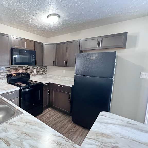 a kitchen with a black fridge and a black stove.