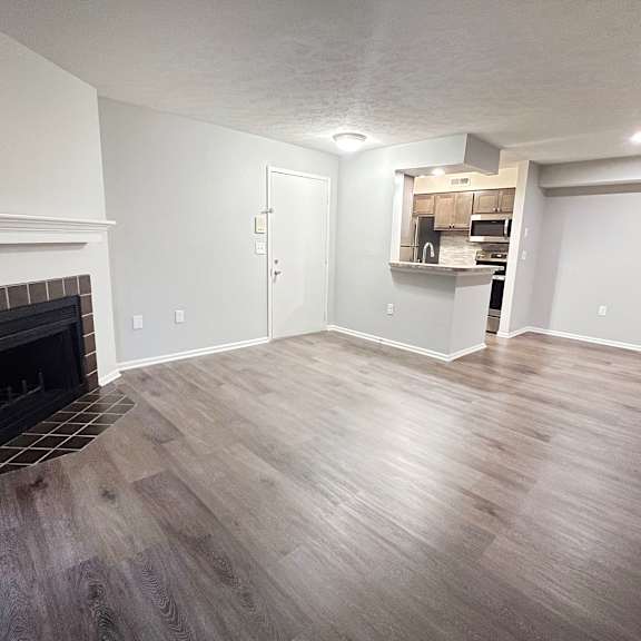 a living room with a fireplace and wooden floors  at deercross apartments, ohio, 45236