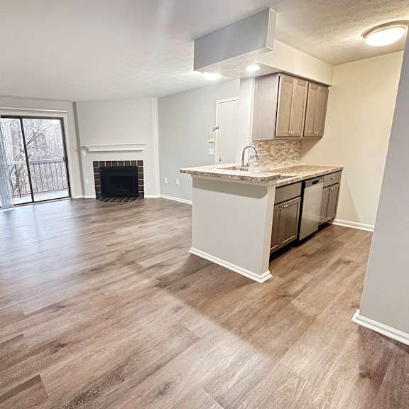 an empty living room with a kitchen and a fireplace  at deercross apartments, cincinnati, 45236
