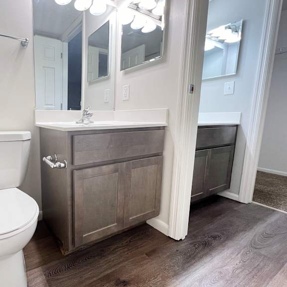 a bathroom with a toilet and a sink and a mirror  at deercross apartments, ohio
