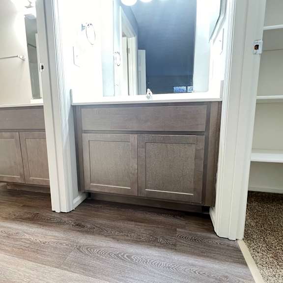 a bathroom with a toilet and a vanity with a mirror  at deercross apartments, cincinnati