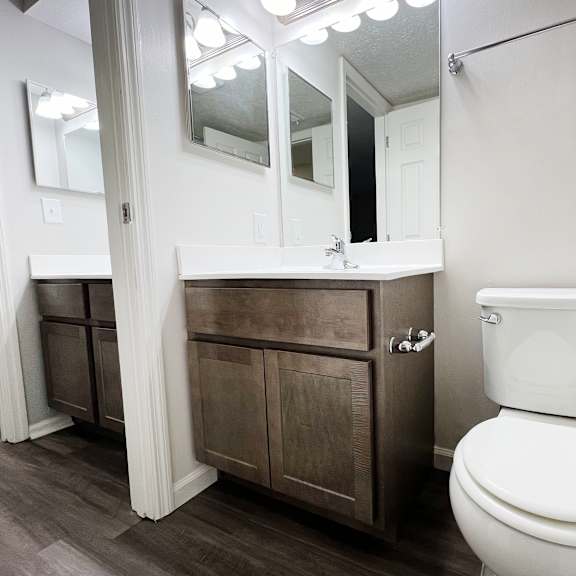 a bathroom with a toilet and a sink and a mirror  at deercross apartments, cincinnati, oh, 45236