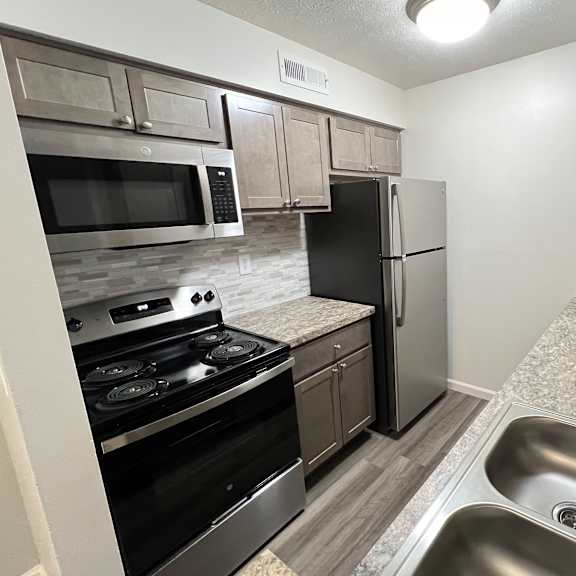 a kitchen with stainless steel appliances and granite counter tops  at deercross apartments, ohio, 45236