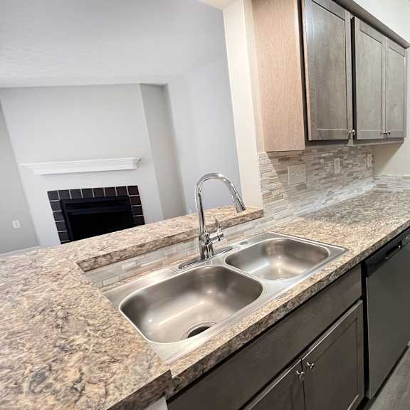 a kitchen with granite counter tops and a stainless steel sink  at deercross apartments, ohio, 45236