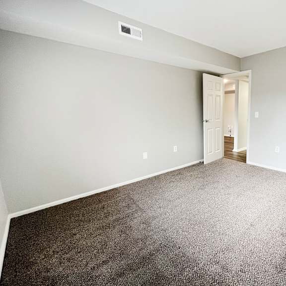 an empty bedroom with carpeting and a closet  at deercross apartments, ohio