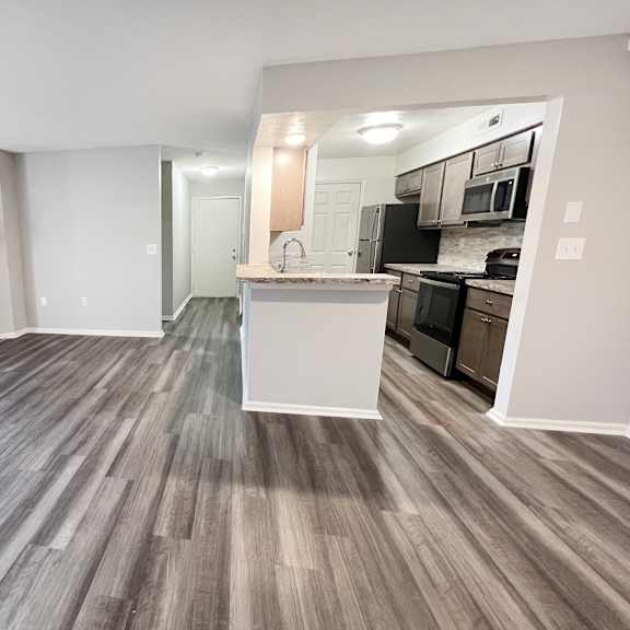 an empty living room with a fireplace and a kitchen  at deercross apartments, cincinnati