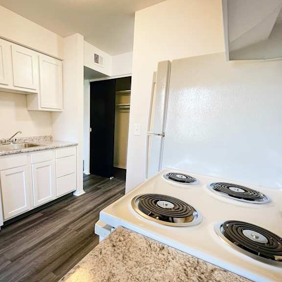 an empty kitchen with white appliances and a white refrigerator at four worlds apartments, cincinnati, oh