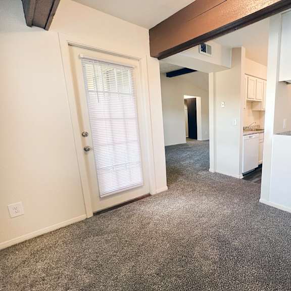 an empty living room with a door to the kitchen and a hallway to the bedroom at four worlds apartments, ohio, 45231