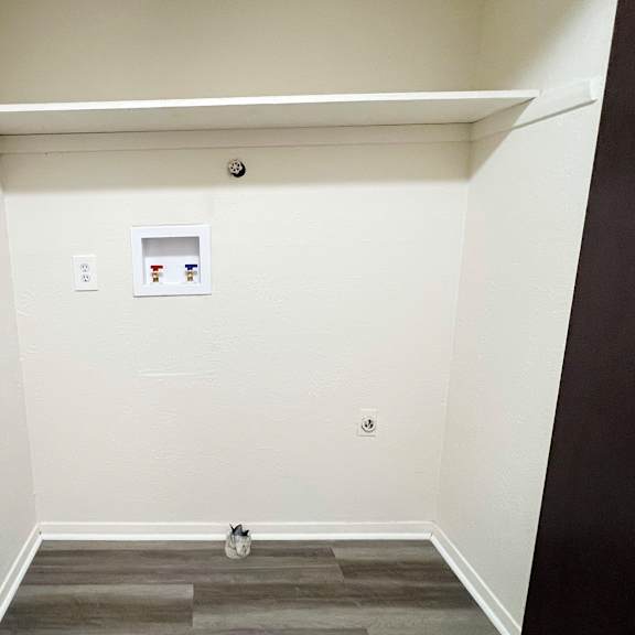 an empty room with a white wall and a door at four worlds apartments, cincinnati