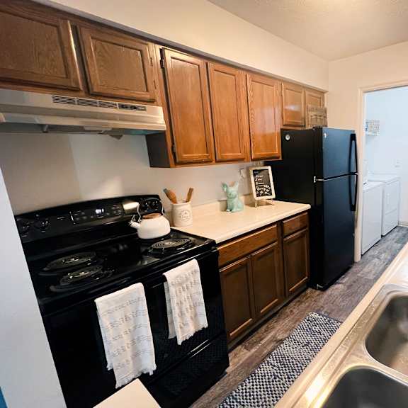 a kitchen with a black refrigerator freezer next to a stove top oven  at steeplechase apartments, ohio, 45140
