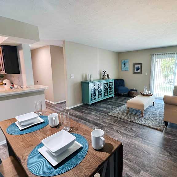a modern dining room with a wooden table set for two.