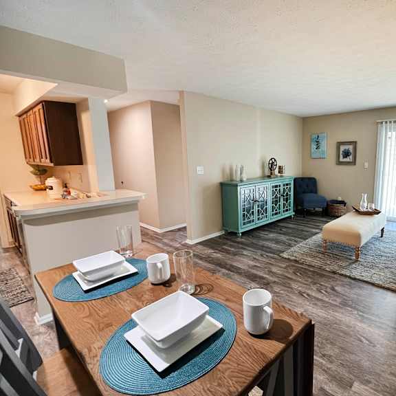 a living room with a dining table and a kitchen in the background  at steeplechase apartments, ohio