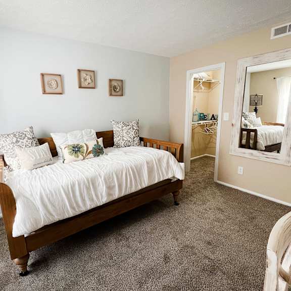 a bedroom with a bed and a lamp  at steeplechase apartments, loveland