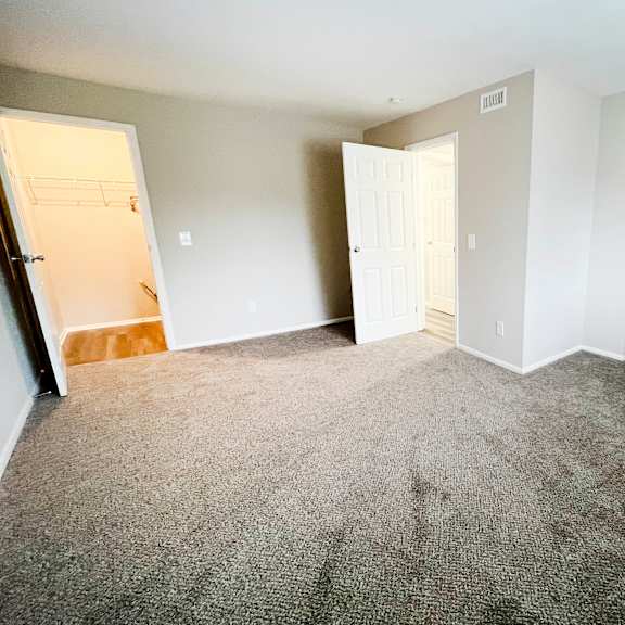 an empty bedroom with a closet and a door open at crown ridge apartments, franklin