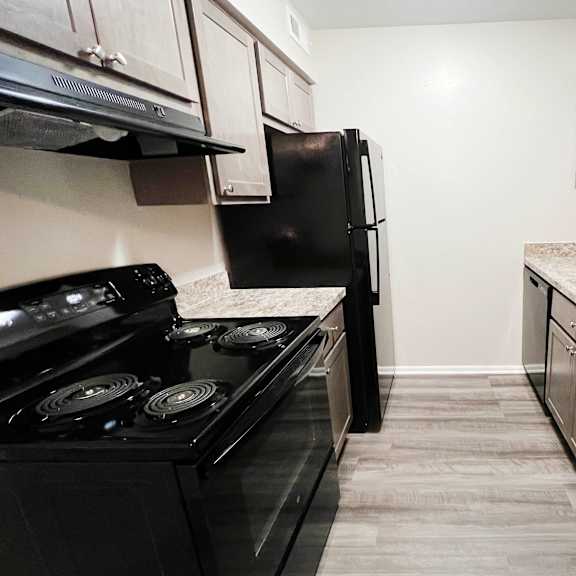 a kitchen with white cabinets and black appliances at crown ridge apartments, ohio