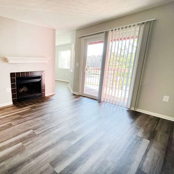 an empty living room with a fireplace and a sliding glass door  at deercross apartments, ohio, 45236