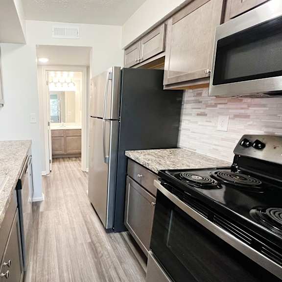 a kitchen with stainless steel appliances and marble counter tops  at deercross apartments, ohio, 45236