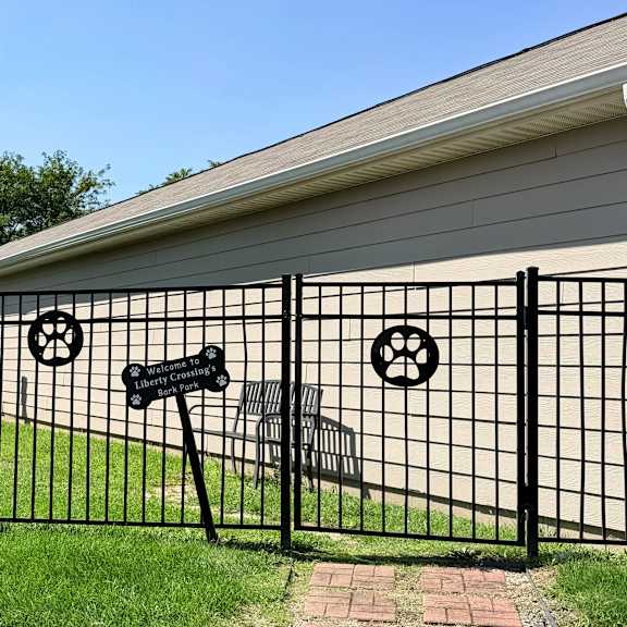 a black metal fence with a mailbox and a wheel design on it.