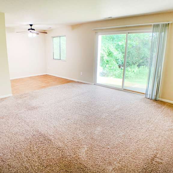 an empty living room with carpet and a sliding glass door  at hunter's creek apartments, ohio, 45242