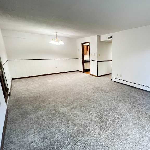 the living room of an empty house with white walls and a concrete floor  at grace court, ft. mitchell, 41017