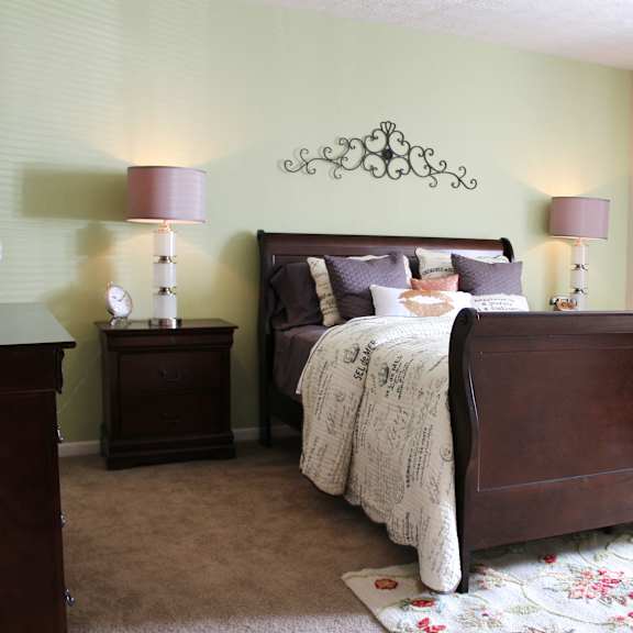 a bedroom with a bed and two lamps  at hunter's creek apartments, ohio, 45242
