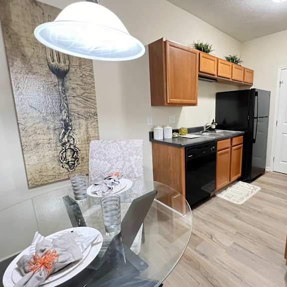 an open kitchen and dining room with a glass table and chairs at residences at northgate crossing, ohio, 43235