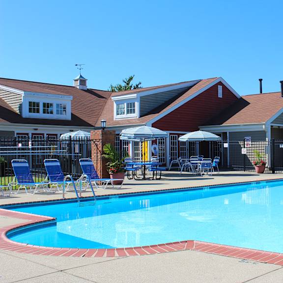 a swimming pool in front of a house with a resort style pool at steeplechase apartments, loveland, 45140