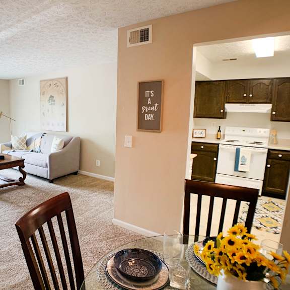 an open living room and kitchen with a table and chairs at knobs pointe apartments, new albany