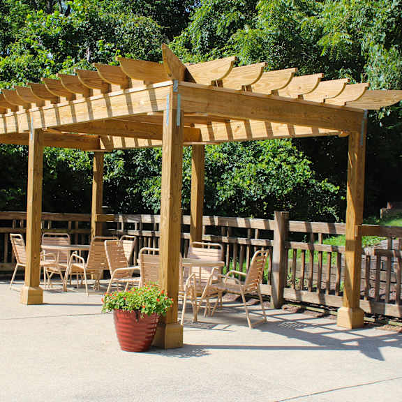 a wooden pergola with tables and chairs under it at the vinings apartments, cincinnati