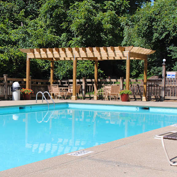 a swimming pool with a wooden canopy next to a resort pool at the vinings apartments, cincinnati, 45245