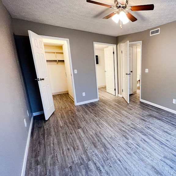 an empty living room with a ceiling fan at quail meadow apartments, ohio