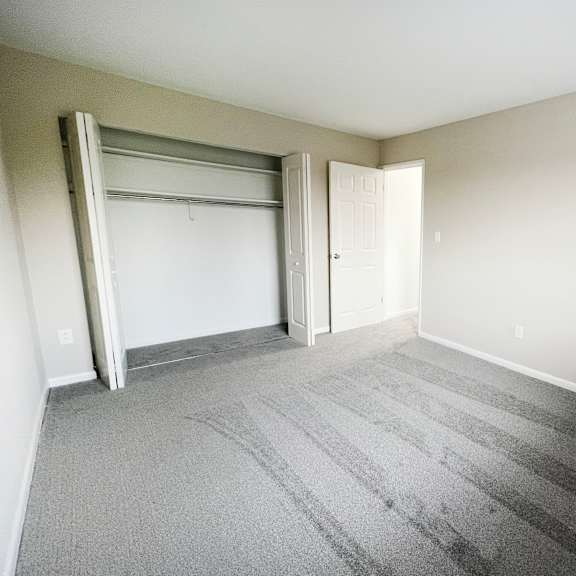 an empty bedroom with a closet and an open door at wentworth estates apartments, florence, ky