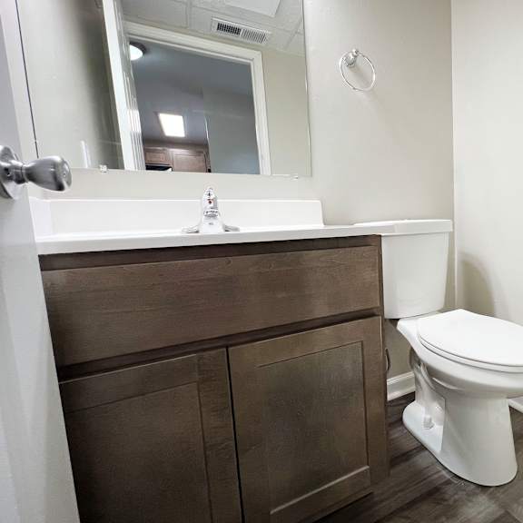 a bathroom with a toilet sink and mirror  at woodhills apartments, west carrollton, 45449