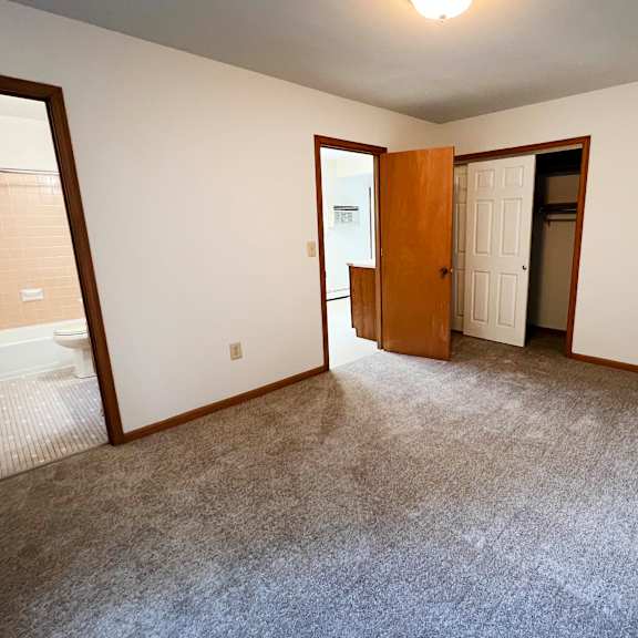 a room with a carpeted floor and a door.