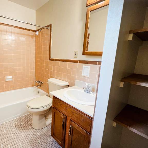 a bathroom with a toilet, sink, and bathtub.