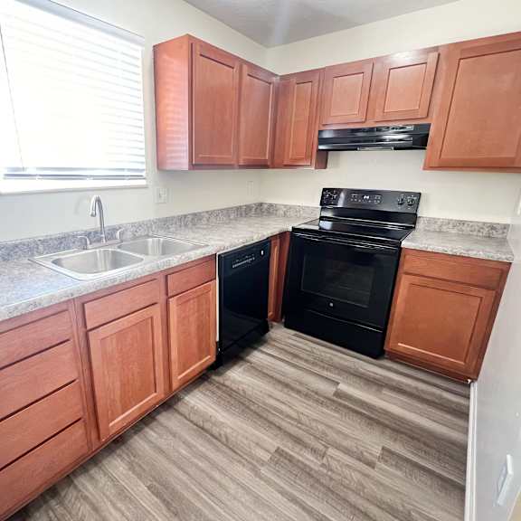 an empty kitchen with wooden cabinets and black appliances at the villas at kingswood, west chester, oh