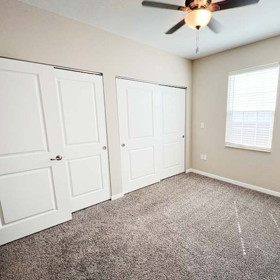 a bedroom with two closets and a ceiling fan at parkway trails, florence
