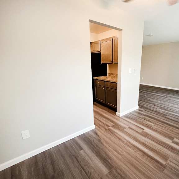 a bedroom with hardwood flooring and a kitchen in the background  at timber ridge apartments, cincinnati, oh, 45241