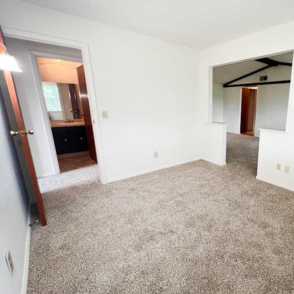 a bedroom with white walls and carpet  at four worlds apartments, ohio