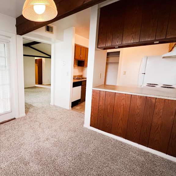 a living room with a white door and a kitchen in the background  at four worlds apartments, cincinnati, oh, 45231
