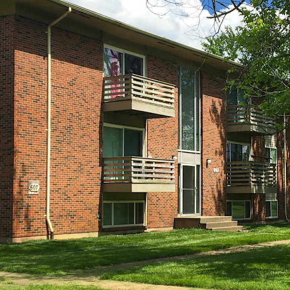 a brick building with a balcony and a flag hanging from it.