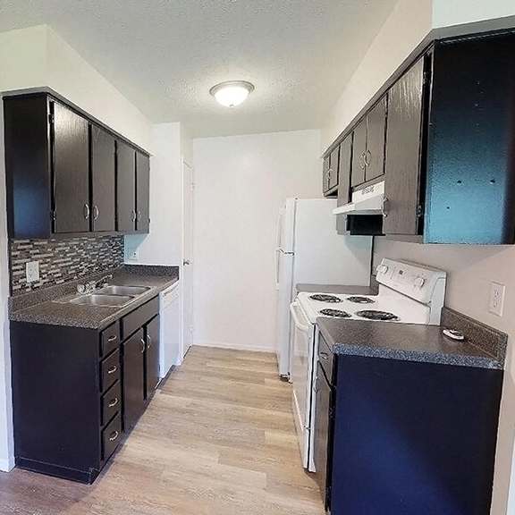 a kitchen with black cabinets and white appliances at hunter ridge apartments, ohio
