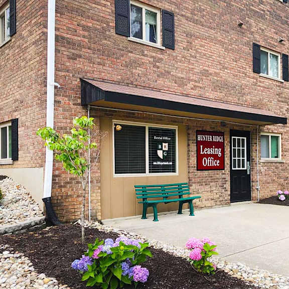 a bench sitting in front of a brick building at hunter ridge apartments, cincinnati, oh